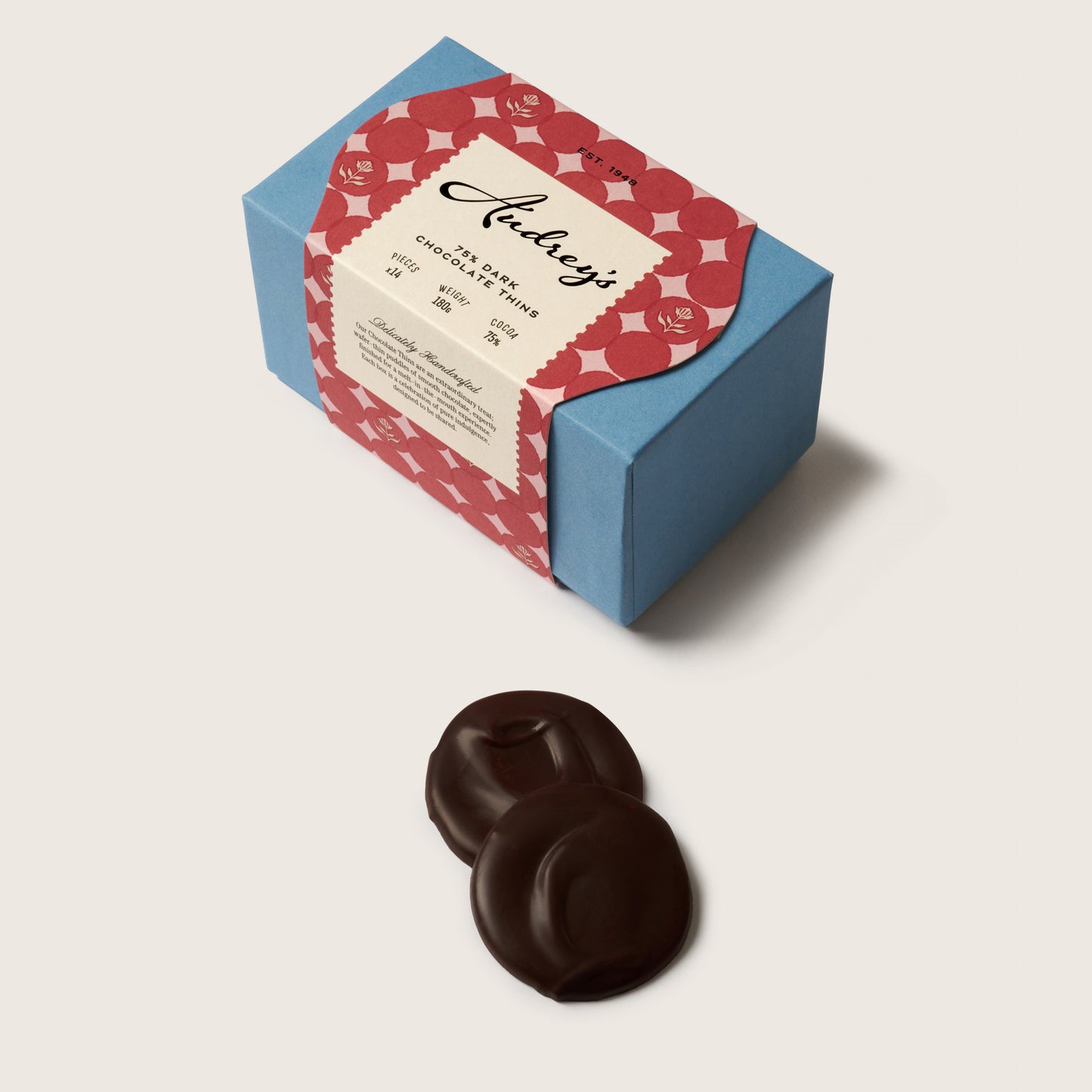 Chocolate candies with a decorative box on a light beige background