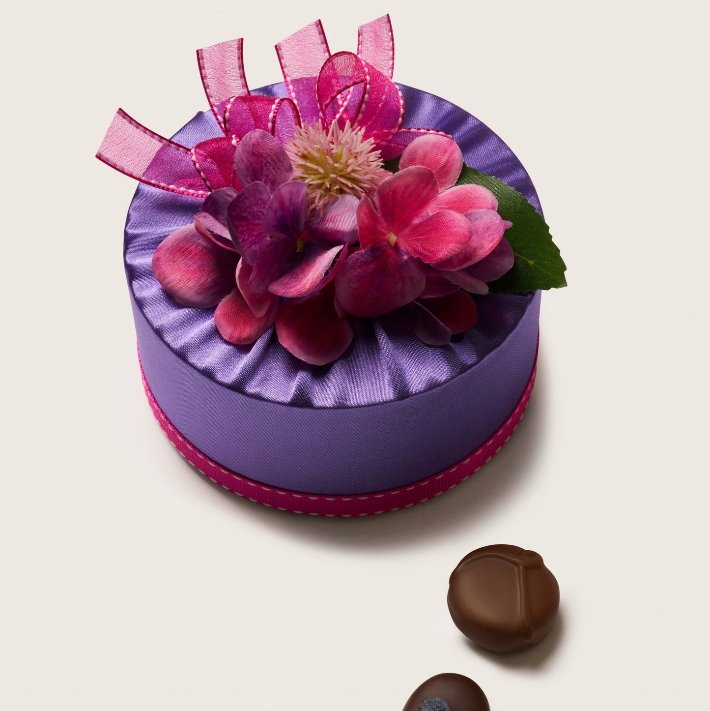 Decorative purple box with pink flowers and ribbons on a white background