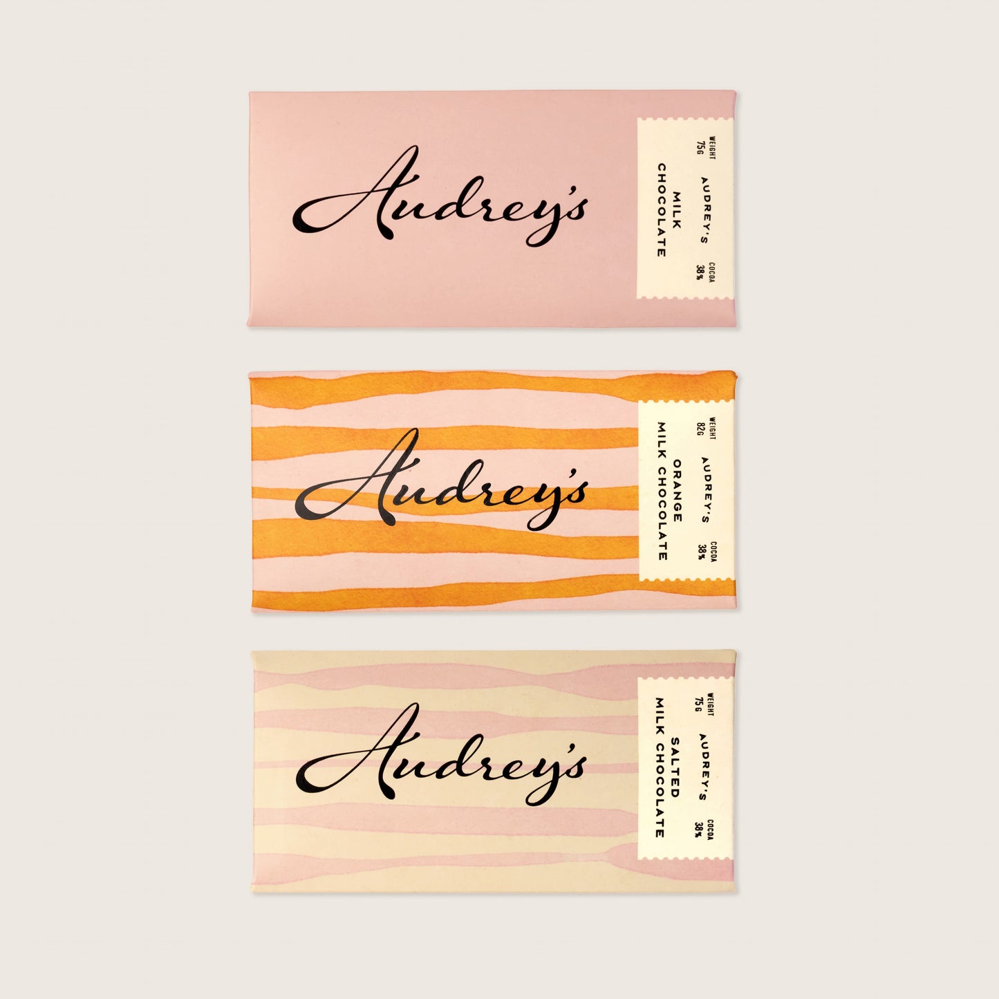 Three business cards with 'Audrey's' branding on a light pink background