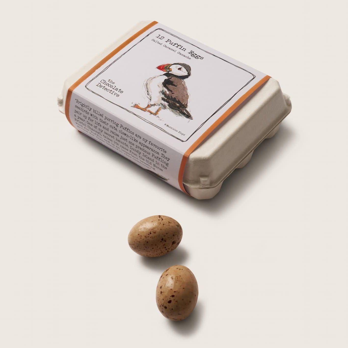 Small box with puffin design and two stones on a light background
