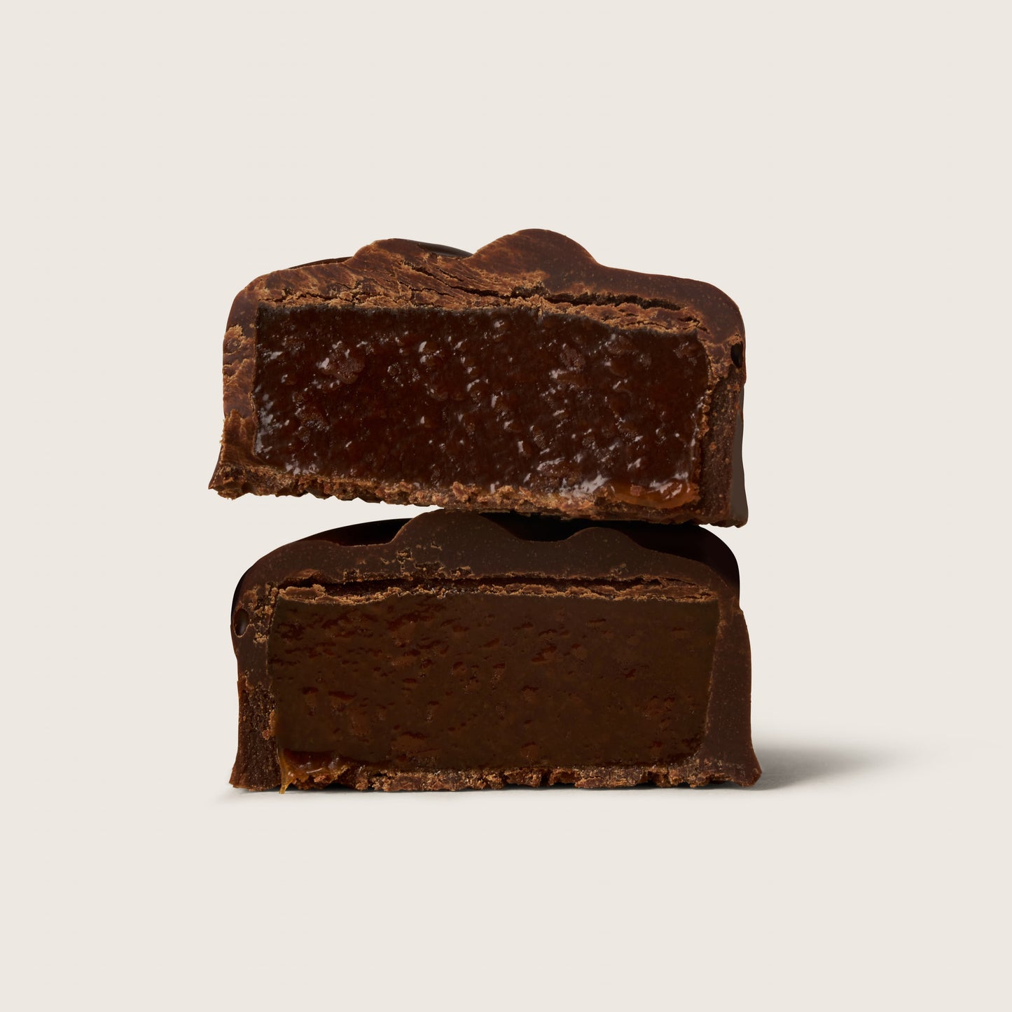 Two pieces of dark chocolate on a light beige background