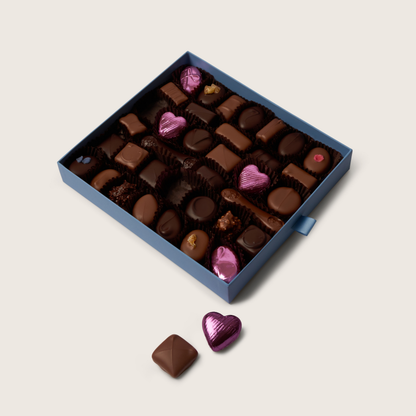 Assorted chocolates in a blue box on a light beige background