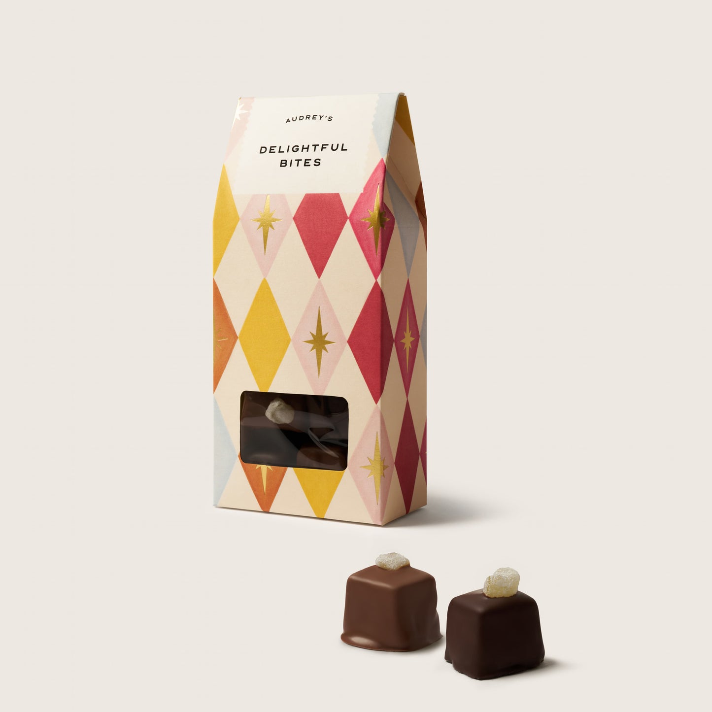 Packaged chocolate bites with a decorative box on a light background