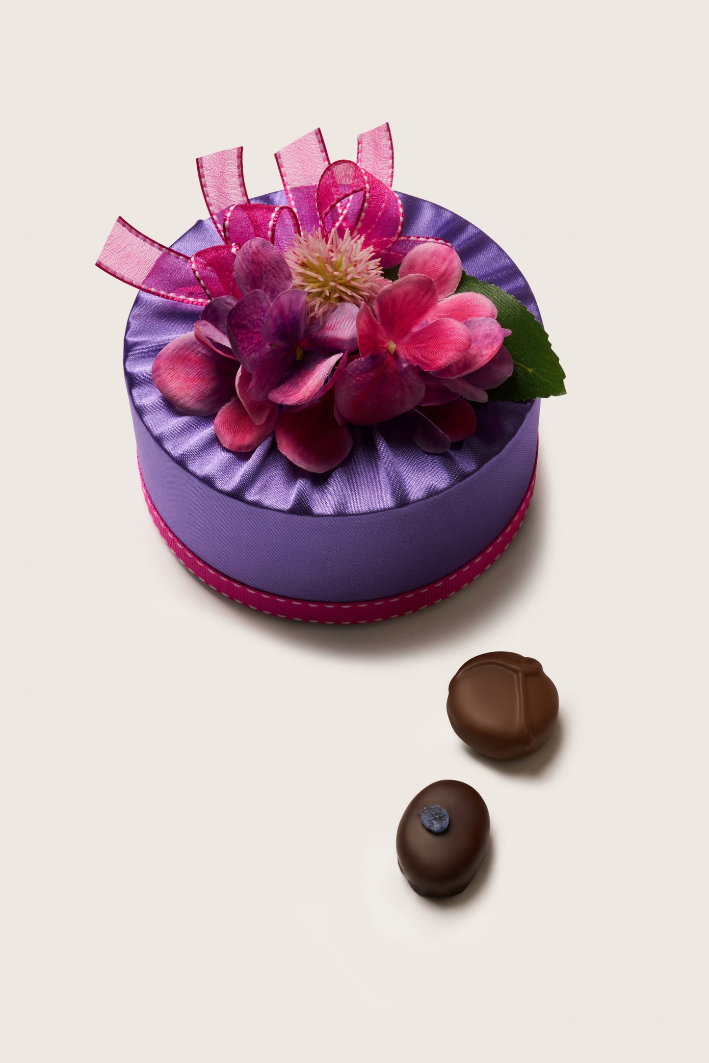 Decorative purple box with pink flowers and ribbons on a white background