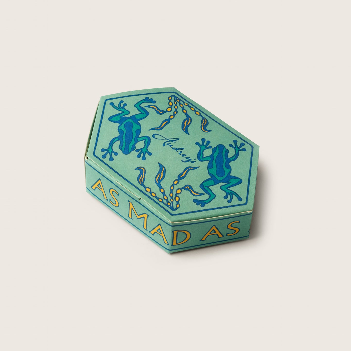 Hexagonal green box with blue frog design and text on a beige background