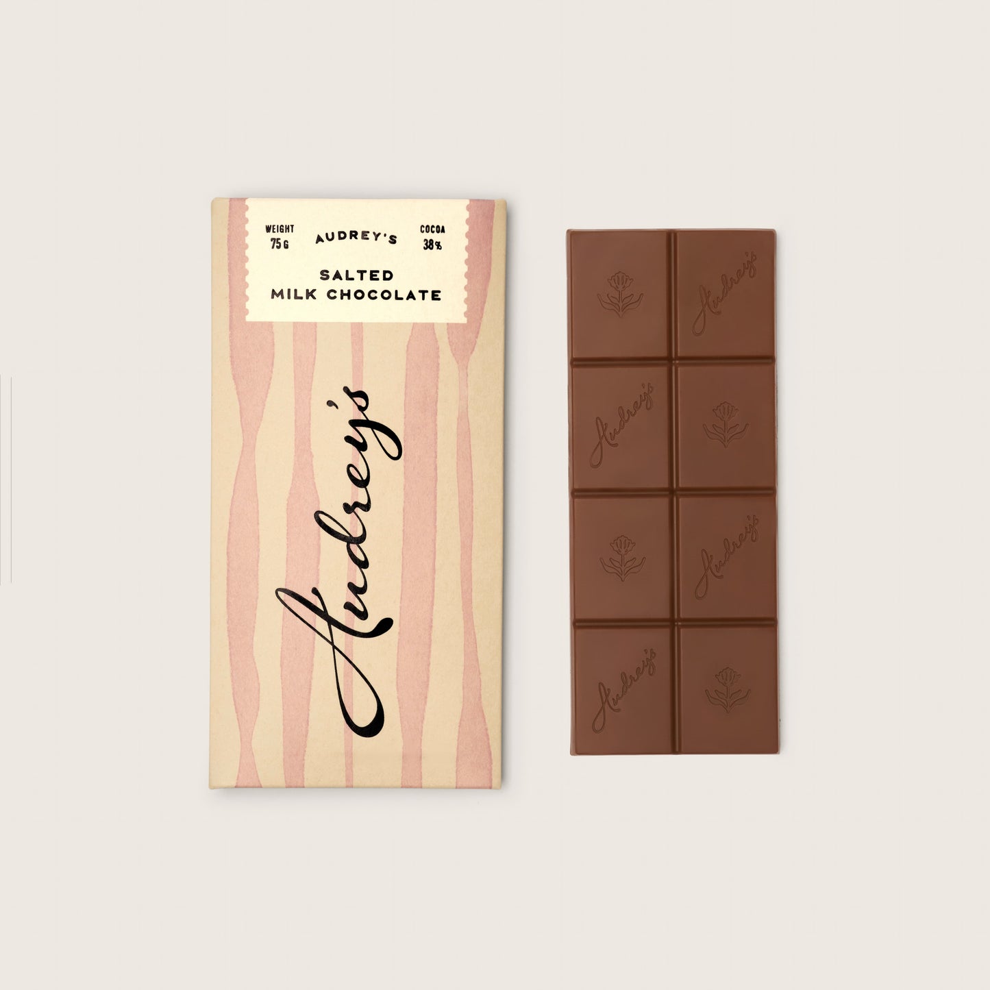 Audrey's salted milk chocolate bar with packaging on a light gray background