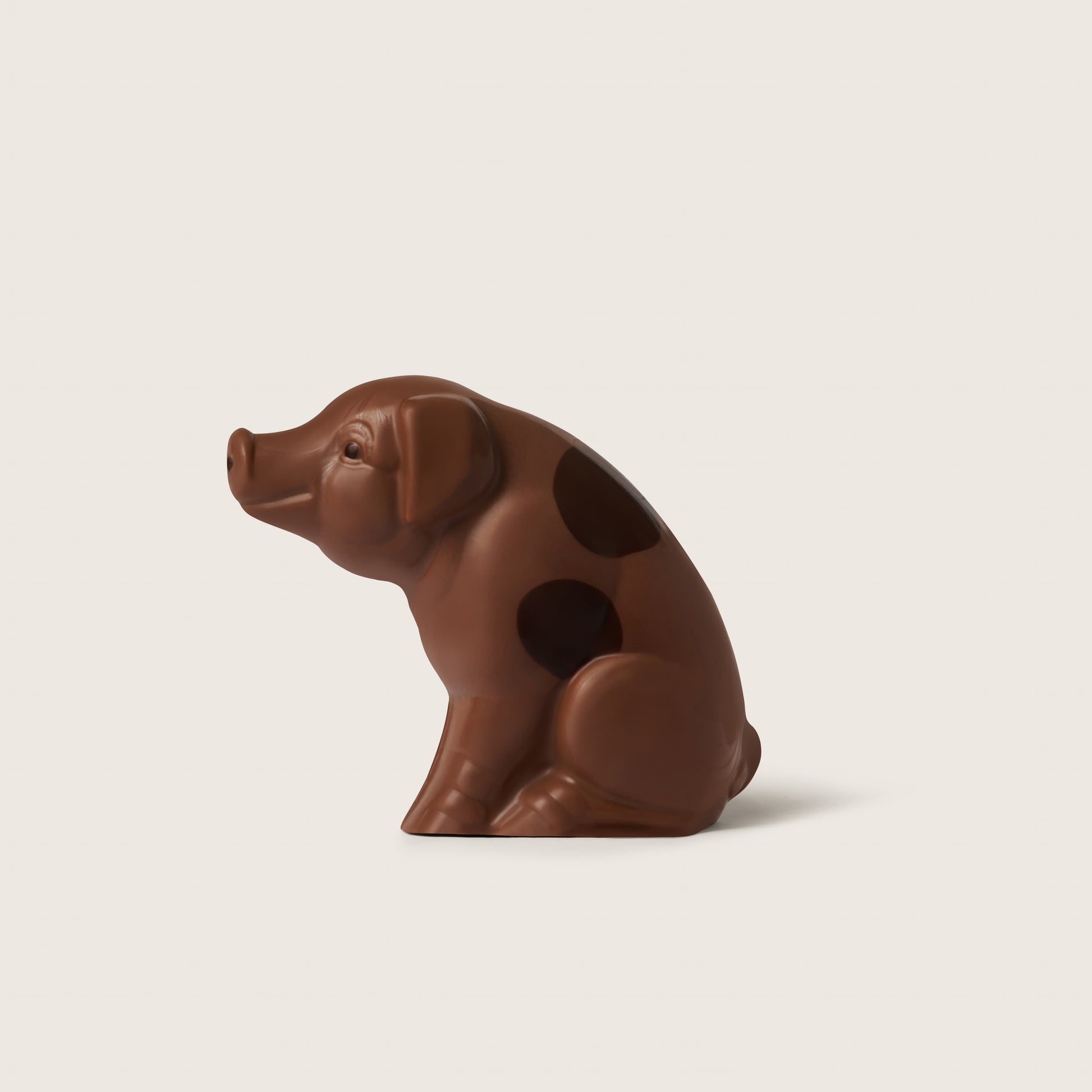 Chocolate pig figurine on a beige background