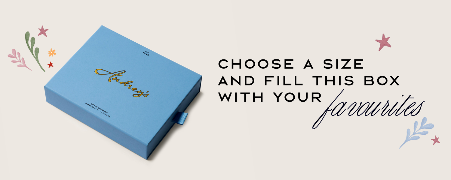 Blue box with 'Audrey' branding on a light background with decorative elements.