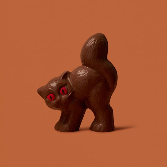 Chocolate cat figurine with red eyes on a brown background