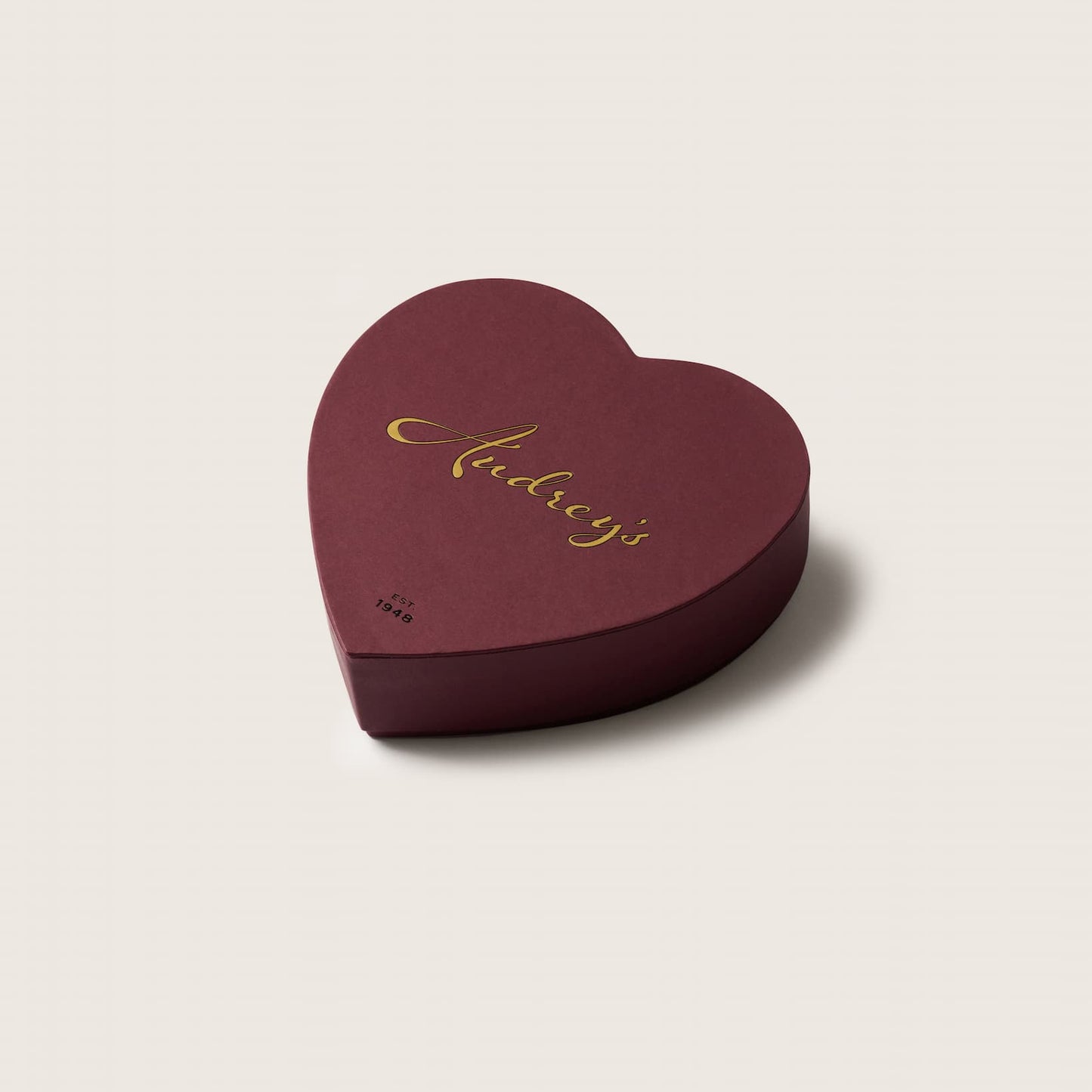 Heart-shaped chocolate box a light beige background 