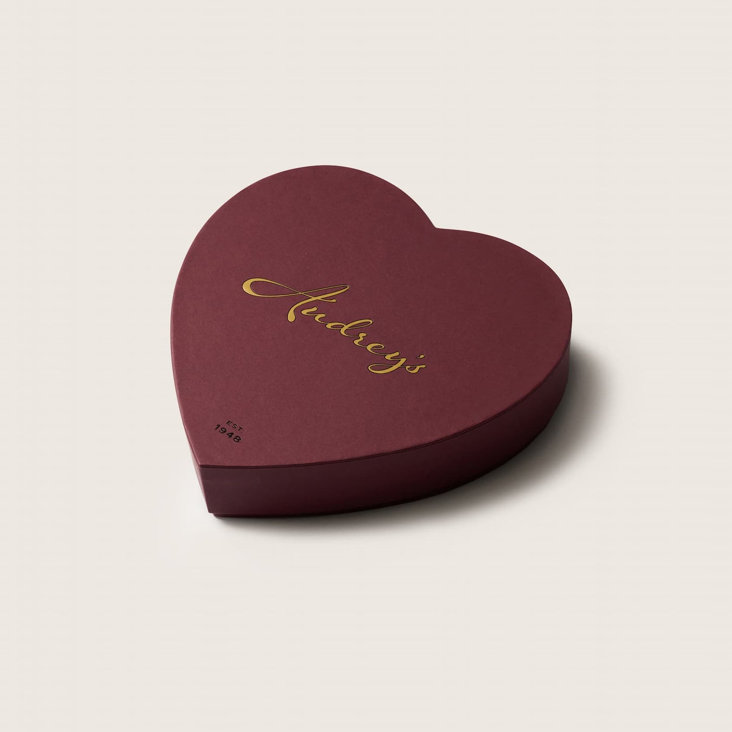 Heart-shaped chocolate box a light beige background