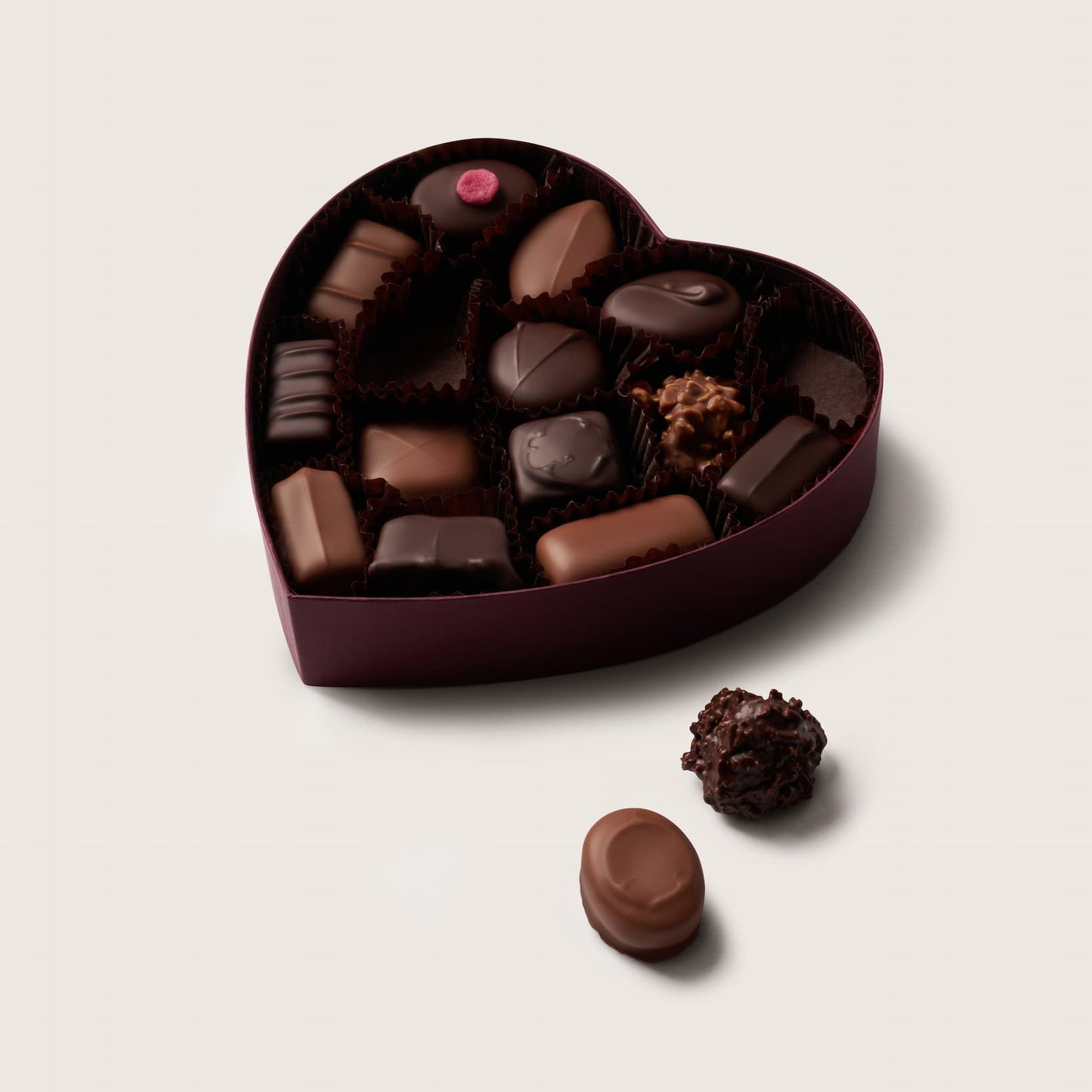 Heart-shaped box of assorted chocolates on a light background