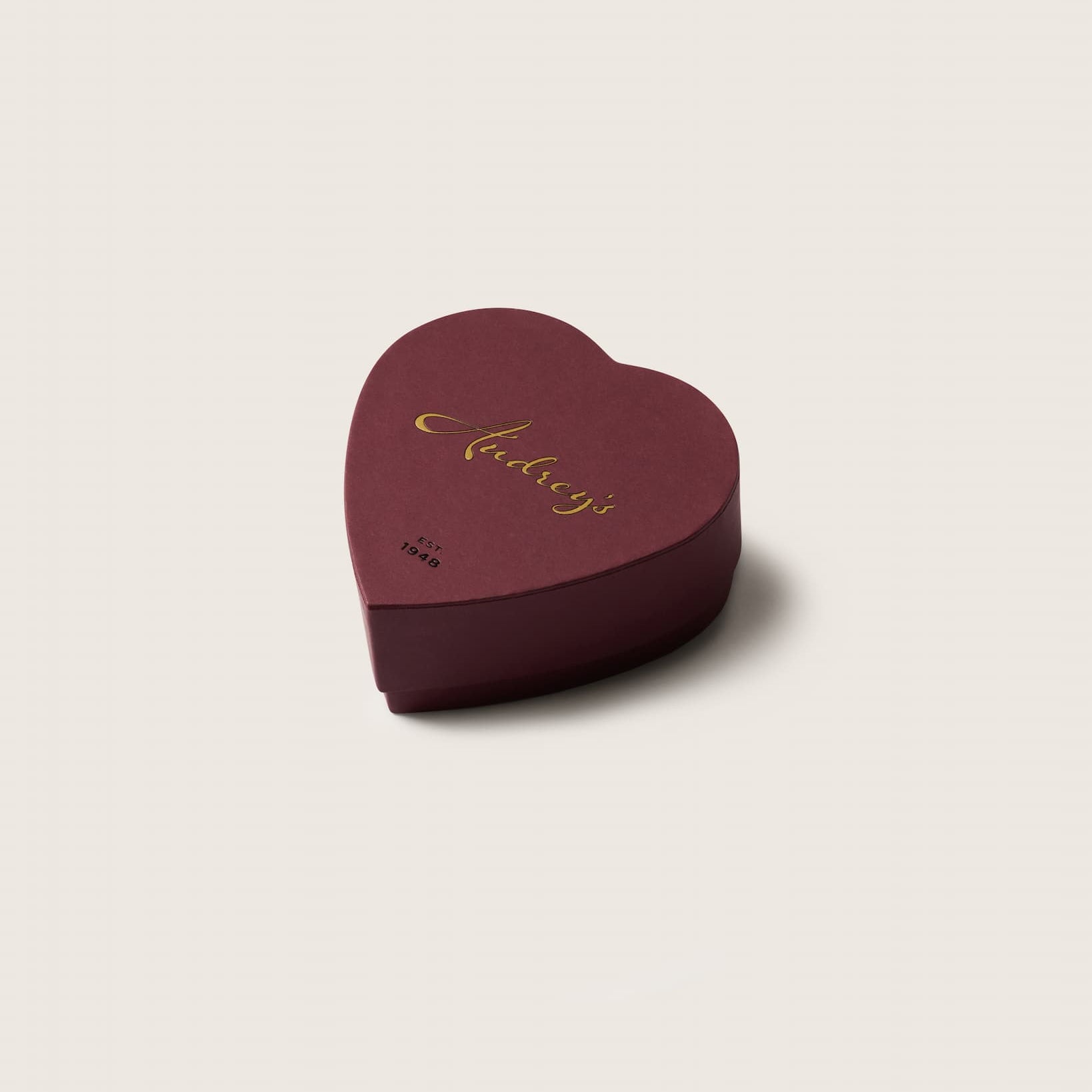 Heart-shaped chocolate box a light beige background