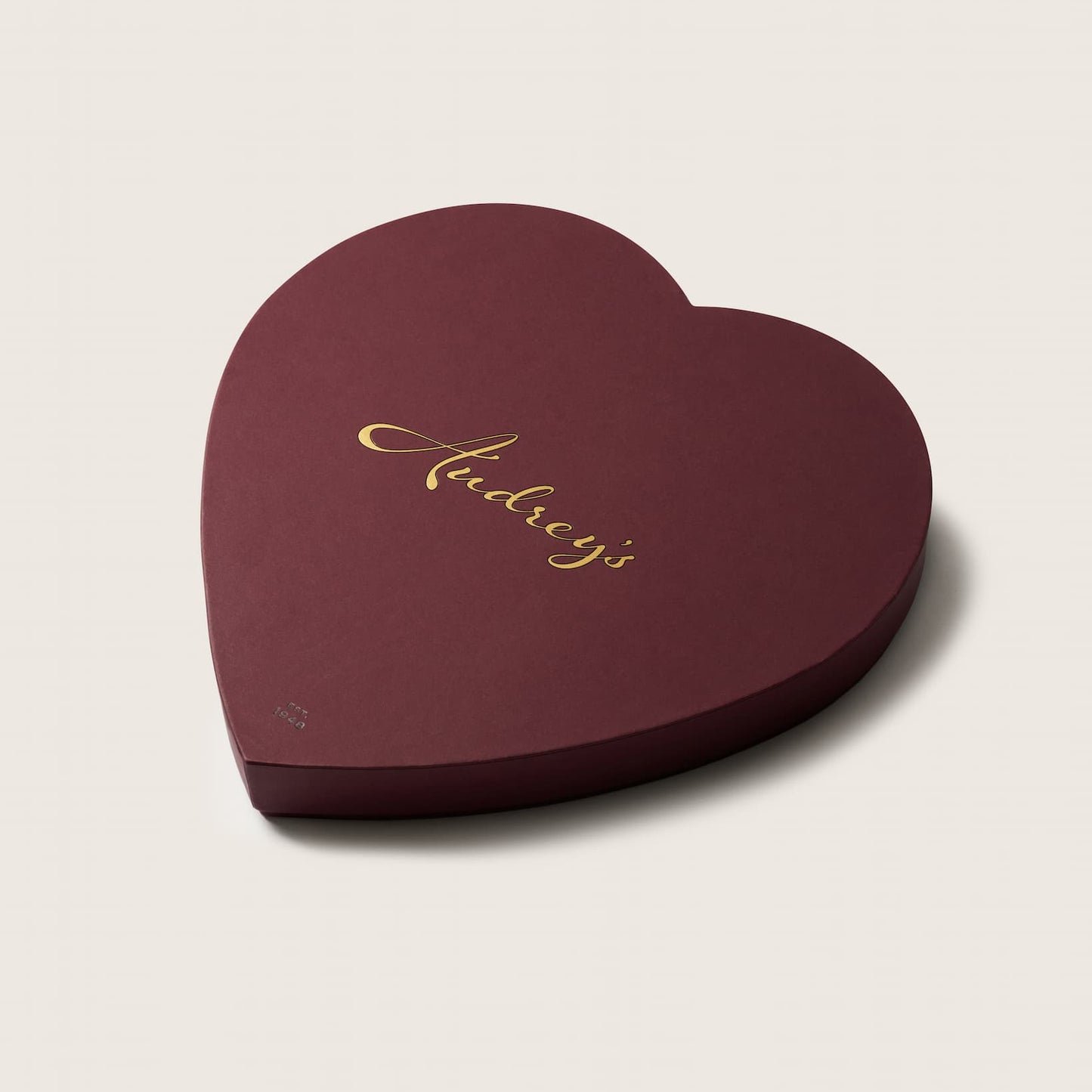 Heart-shaped chocolate box a light beige background