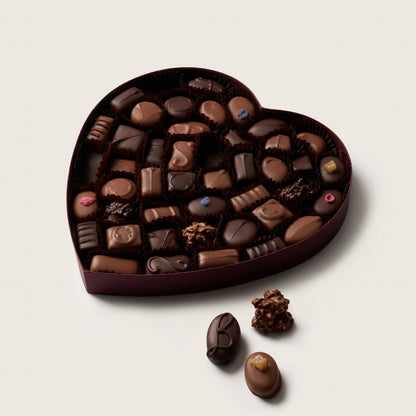Heart-shaped chocolate box with assorted chocolates on a light background