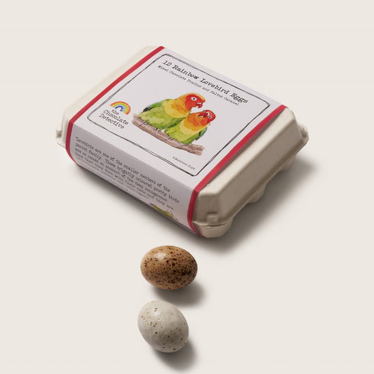 Small box with a label featuring an illustration of food, next to two small stones on a light background