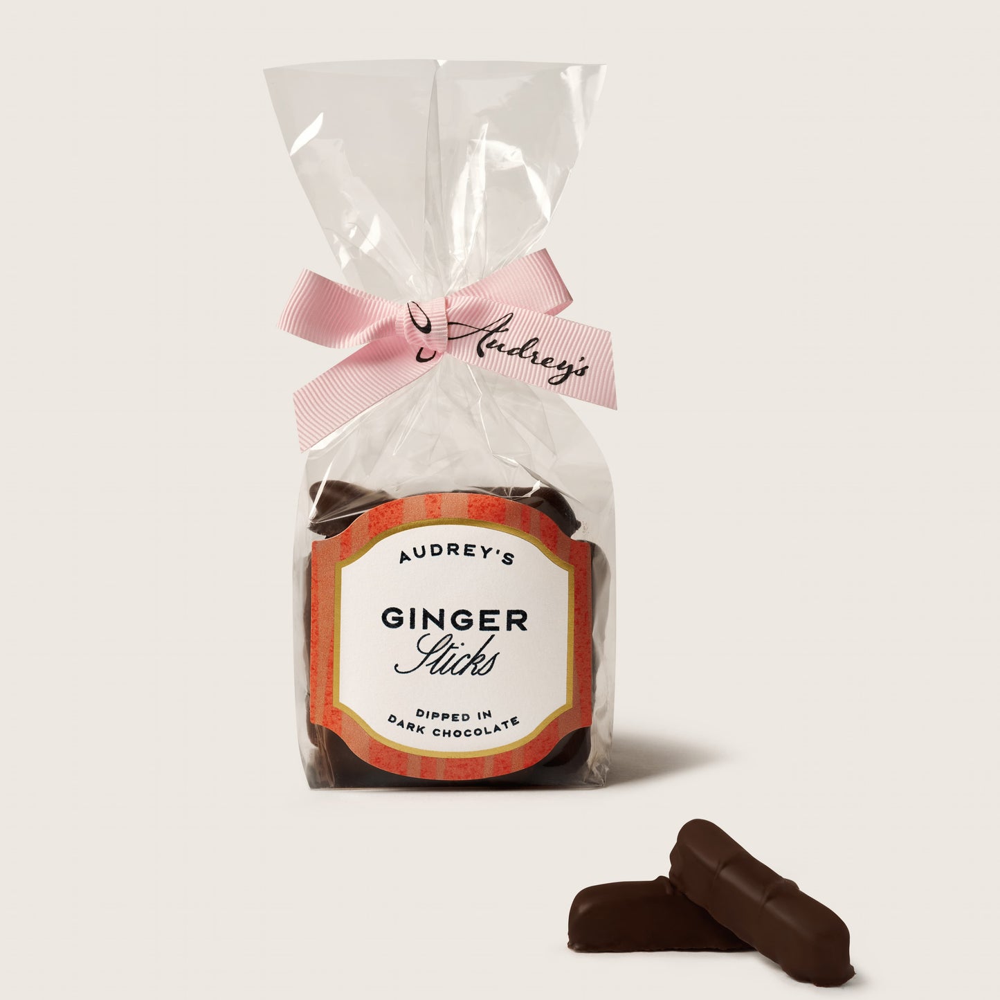 Packaged ginger licks with a pink ribbon on a white background