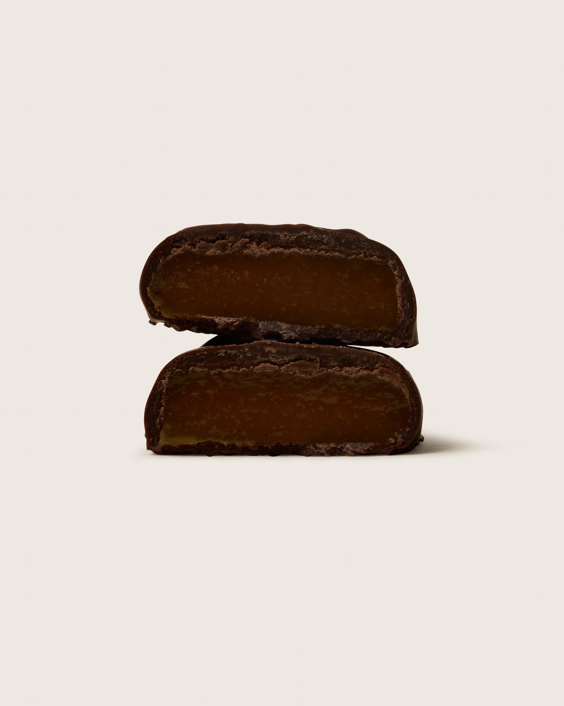 Two dark brown rectangular cookies on a light beige background