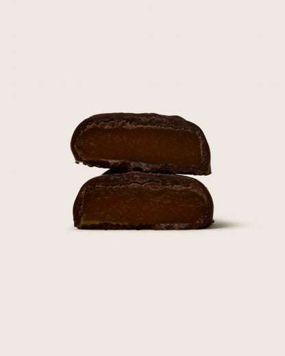 Two dark brown rectangular cookies on a light beige background
